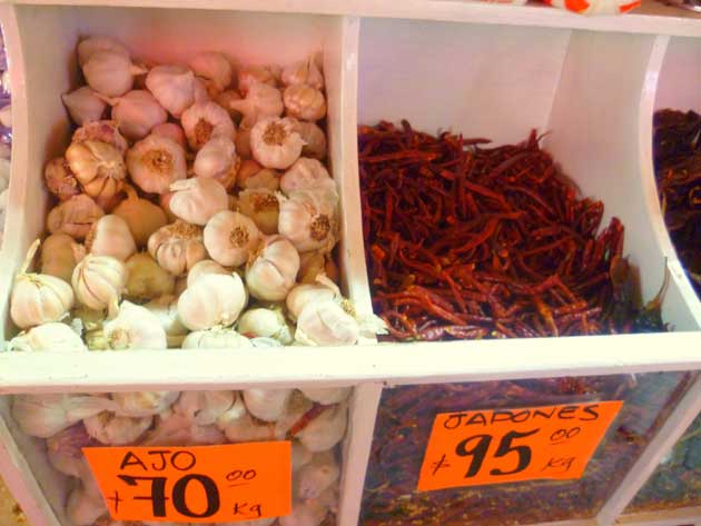 Bins of garlic and chiles for sale at a Los Globos open air market stall in Ensenada, Baja California Norte, Mexico.